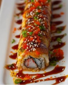 a white plate topped with sushi covered in sauce