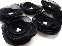 black fabric flowers with white buttons on them