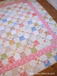 a pink and blue quilt on the floor