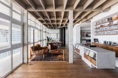 a living room filled with furniture and lots of windows next to a wall covered in bookshelves