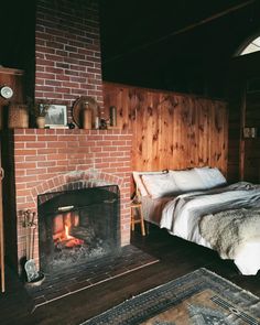 a bed sitting next to a fire place in a bedroom