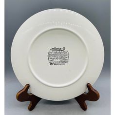 a white and brown plate with wooden stand on it's sides, in the shape of an elephant