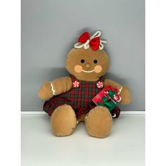 a brown teddy bear wearing a red bow and holding a candy cane in its hand