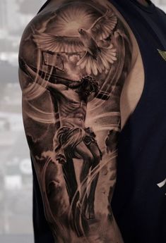 a man with a cross and dove tattoo on his arm