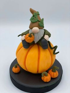 a small figurine sitting on top of a pumpkin