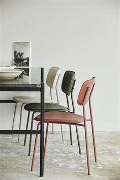 four chairs sitting on top of a table next to a bowl and plate in front of it