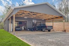 two trucks are parked in front of a garage with an american flag on the roof