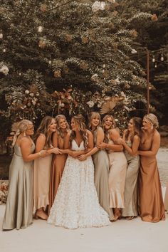 a group of women standing next to each other in front of a tree with flowers