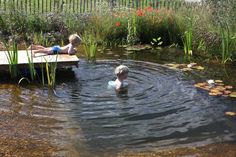 two children are playing in the pond