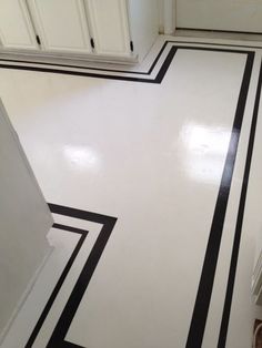 a white and black striped floor in a kitchen with cupboards on the far side