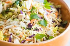 a bowl filled with coleslaw and dressing on top of a table