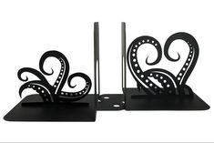 two black metal bookends with designs on them