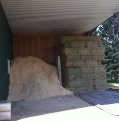 large pile of hay sitting in the back of a building