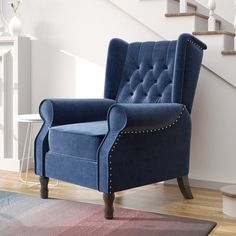 a blue chair sitting on top of a wooden floor next to a stair case in a living room