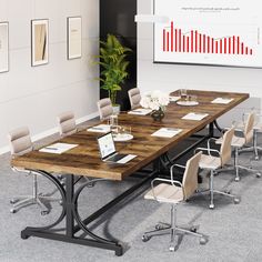 a conference table with chairs around it and a laptop computer on the desk in front of it