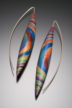 two earrings with colorful designs on them