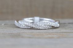 a white gold wedding band with pave set diamonds on the outside and in the inside