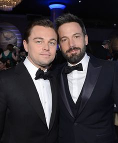 two men in tuxedos posing for the camera