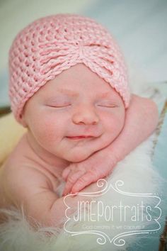 a newborn baby wearing a pink knitted hat