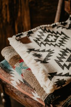 three blankets sitting on top of a wooden chair