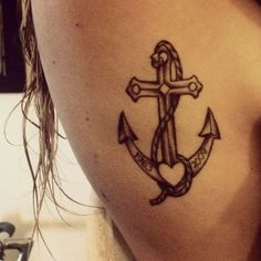 an anchor tattoo on the back of a woman's shoulder