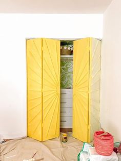 an open yellow door in the middle of a room with other items on the floor