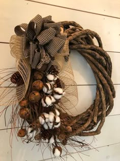 a wreath with cotton and pine cones is hanging on the wall