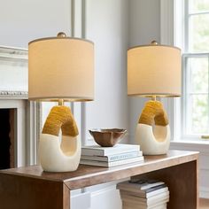 two lamps sitting on top of a wooden table