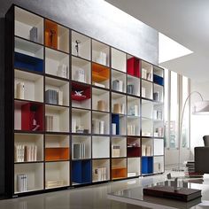 a living room filled with lots of furniture and bookshelves next to a window