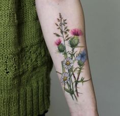 a woman with a flower tattoo on her arm