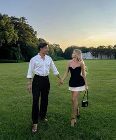 a man and woman are holding hands in the grass