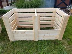 a wooden box sitting on top of grass next to a garden bed in the middle of a yard