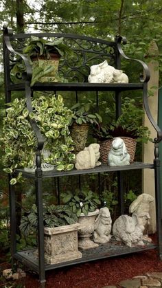 an iron shelf filled with potted plants and statues