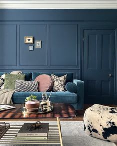 a living room with blue walls and furniture in the corner, including a couch, coffee table