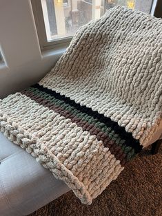 a blanket is sitting on the floor next to a window