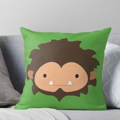 a green throw pillow with a cartoon monkey face on it's front and back