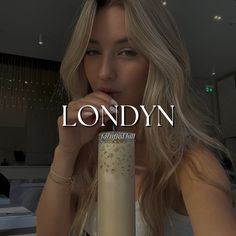 a woman holding a tall glass in front of her face with the words london on it