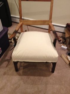 a white chair sitting on top of a carpeted floor next to a wooden frame