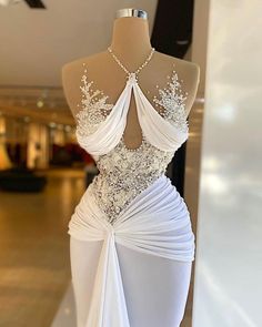 the back of a dress on display in a store window, with white fabric and beading