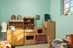 a kitchen with wooden cabinets and lots of toys on the floor in front of it