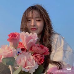 a woman holding flowers in front of her face