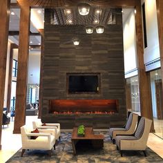 a living room filled with furniture and a flat screen tv mounted on the wall above a fire place