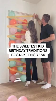 a man and woman standing in front of a birthday balloon wall with the words, the sweetest kid birthday traditions to start this year