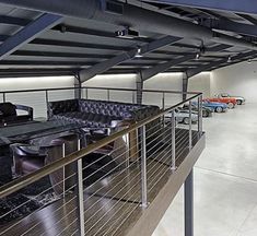 the interior of a car showroom with leather furniture and race cars on the floor