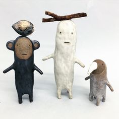 three small figurines are standing next to each other