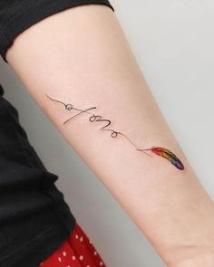 a woman's arm with the word love written on it and an arrow tattoo