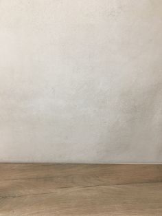 an empty wooden table with a white wall in the background and a vase on top