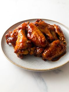 some chicken wings are on a plate and ready to be eaten by the person in the photo