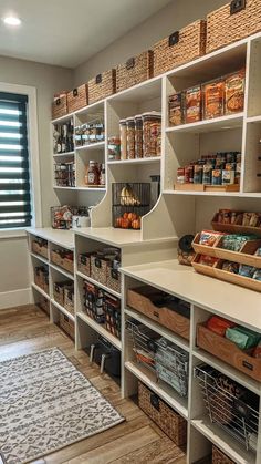 an organized pantry with lots of shelves and bins full of food, along with baskets on the floor