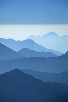 the mountains are covered in blue haze as seen from an airplane